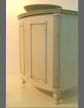 Bow-front cabinet with applied moldings and a glazed finish.